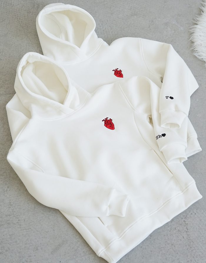 "A stylish white hoodie featuring bold graphic prints on the front, designed for a contemporary look. The hoodie has a relaxed fit, adjustable drawstrings, and a spacious front pocket. Made from soft, breathable fabric, it combines comfort with a trendy aesthetic, making it perfect for casual outings or lounging."