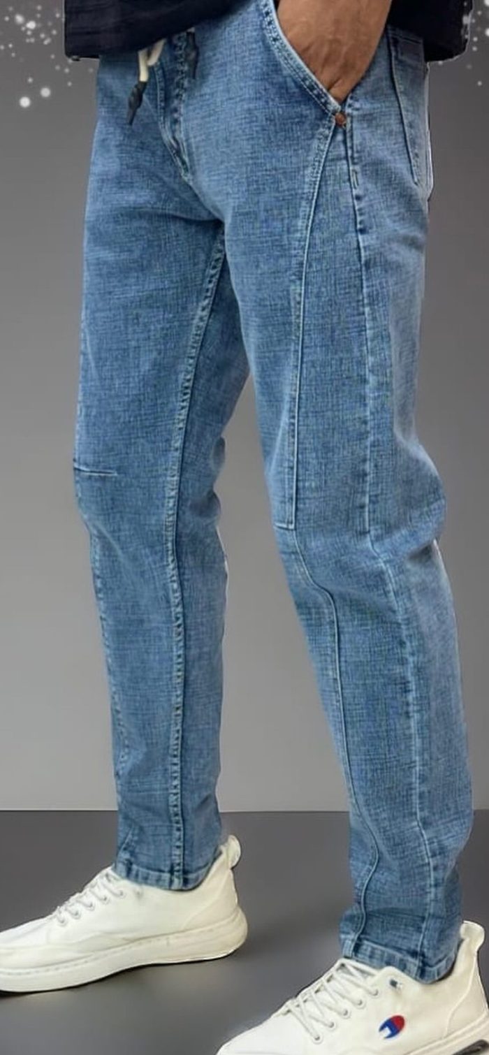 "Stylish blue jeans displayed on a wooden surface, showcasing a classic design with a modern fit. The jeans feature a flattering cut, high-quality denim, and subtle details, emphasizing comfort and versatility for any outfit."