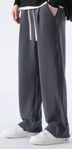 "Stylish baggy trousers displayed on a plain background, featuring a relaxed fit and contemporary design. The trousers are made from lightweight fabric in a versatile color, showcasing a comfortable waistband and side pockets, perfect for achieving an effortless and fashionable look."